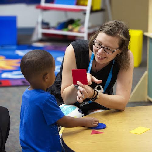 Ms. Amy Newsom, works with a student to identify basic shapes. 