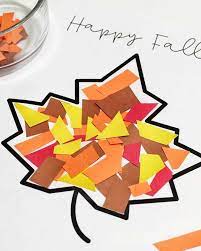 Colorful paper pieces are arranged on a black outline of a leaf, with "Happy Fall" written above.